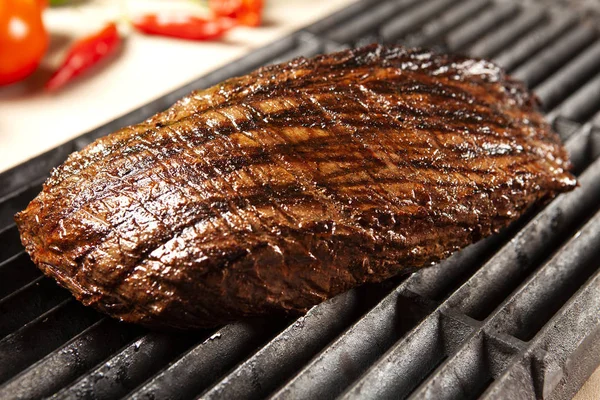 Deliciosa carne grelhada sobre a grelha em um churrasco — Fotografia de Stock