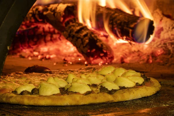 Pizza italiana en un horno de leña — Foto de Stock