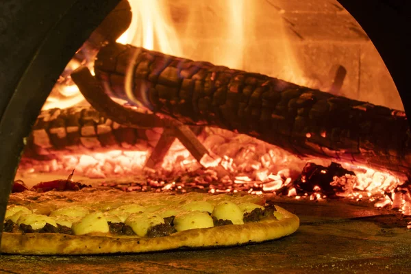 Pizza italiana en un horno de leña — Foto de Stock