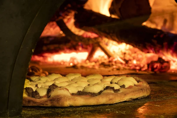 Pizza italiana en un horno de leña — Foto de Stock