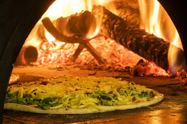 Pizza italiana en un horno de leña — Foto de Stock