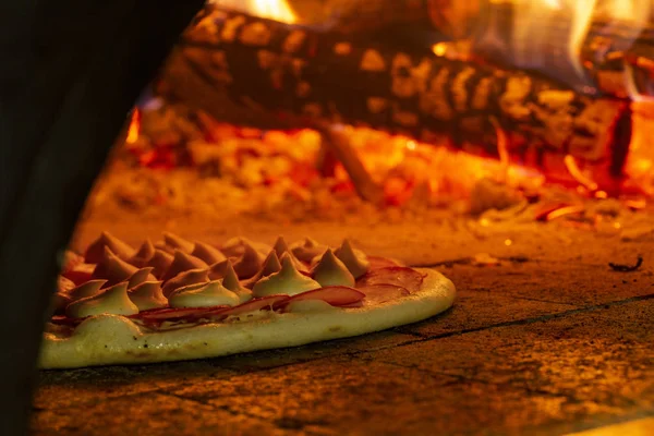 Pizza italiana en un horno de leña — Foto de Stock