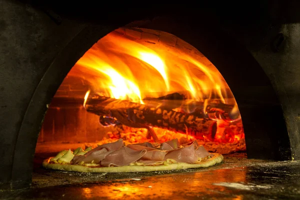 Pizza italiana en un horno de leña — Foto de Stock