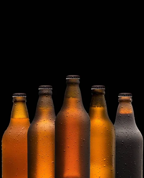 Concepto de branding y marketing para la cerveza con una línea de botellas marrones en blanco sin etiquetar y sin abrir sobre un fondo oscuro y sombrío conceptual de Oktoberfest o vida nocturna —  Fotos de Stock