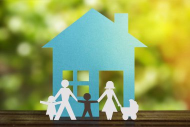 Çocuklarla el ele tutuşan bir çiftin ve üvey siyah bir çocuğun kağıt figürü. Ev ve bulanık arka plan. Çeşitlilik, azınlık kavramı