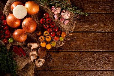 Tahta masa manzaralı sebzeler. Domates, sarımsak ve soğan.