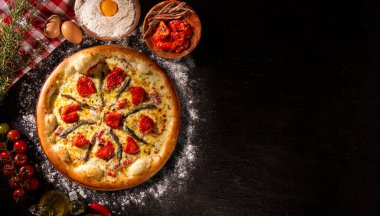 Siyah beton arka planda pizza ançüez ve kurutulmuş domates. Üst Manzara, kapat. Geleneksel Brezilya Pizzası
