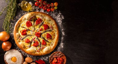 Siyah beton arka planda pizza ançüez ve kurutulmuş domates. Üst Manzara, kapat. Geleneksel Brezilya Pizzası