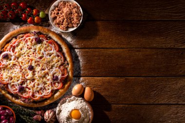 Pizza ton balığı, soğan, domates ve ahşap zemin üzerinde siyah zeytin. Üst Manzara, kapat. Geleneksel Brezilya Pizzası