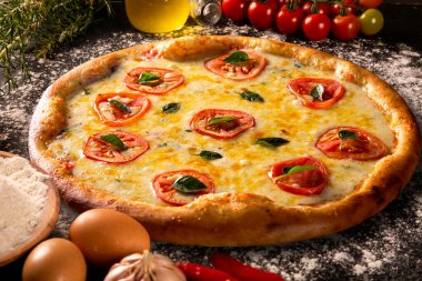 Ahşap kırsal arka planda çeşitli sebzeler ve yuvarlak pizza masasının üzerinde kopyalanmış alan. Taze sebzeler. Yumurta, domates, biber, marul, soğan, sarımsak, soğan. Pizza malzemeleri.