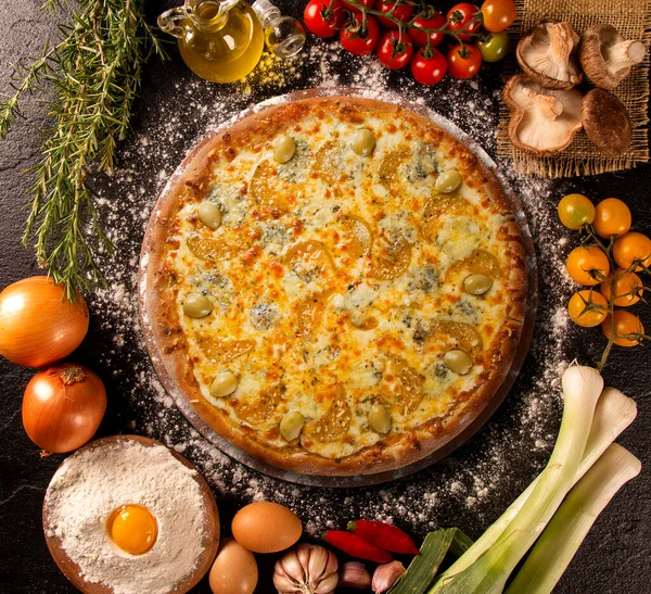 Tasty gorgonzola cheese and zucchini pizza and cooking ingredients tomatoes basil on wood background. Top view gorgonzola cheese and zucchini pizza