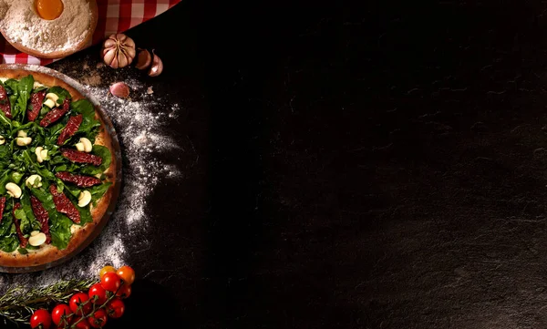 Leckere Rucola Und Getrocknete Tomatenpizza Und Kochzutaten Tomaten Basilikum Auf Stockfoto