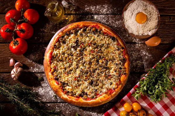 Verschiedenes Gemüse Vor Rustikalem Holzhintergrund Mit Kopierraum Auf Rundem Pizzatisch Stockbild