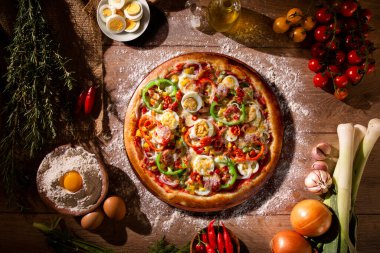 Kırmızı biberli pizza, yeşil biber, yumurta ve pepperoni. Ahşap arka plan manzaralı, yakın çekim. Geleneksel Brezilya Pizzası