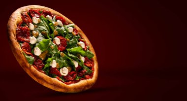 Kurutulmuş domates, roka ve hardallı Brezilya pizzası. Kırmızı arkaplanda yan görüş, yakın çekim. Geleneksel Brezilya Pizzası.