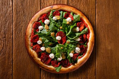 Kurutulmuş domates, roka ve hardallı Brezilya pizzası. Ahşap arka plan manzaralı, yakın çekim. Geleneksel Brezilya Pizzası.