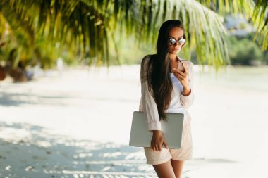 Sahilde çalışma serbest meslek. Uzaktan internet üzerinden dizüstü bilgisayar üzerinde çalışan erkek. Seyahat ederken çalışma. Yaz tatili de Seyşeller.