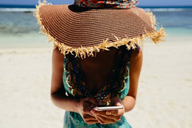 tropik plajda Smartphone kullanan kadın. Erkek seyahat ve smartphone Seyşeller plaj üzerinde kullanın.