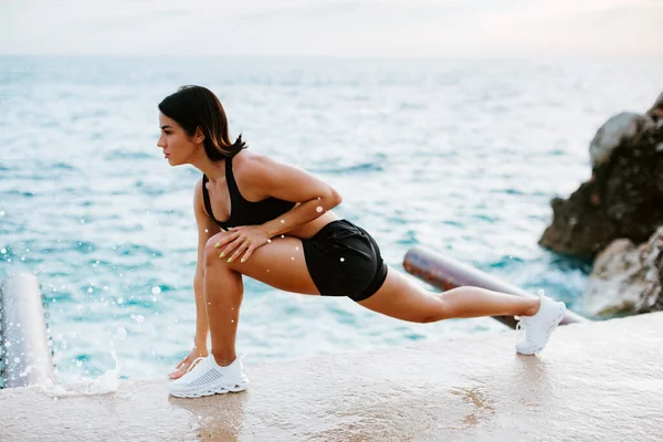 Wanita Atletik Seksi Melakukan Latihan Luar Ruangan Dengan Pemandangan Laut — Stok Foto