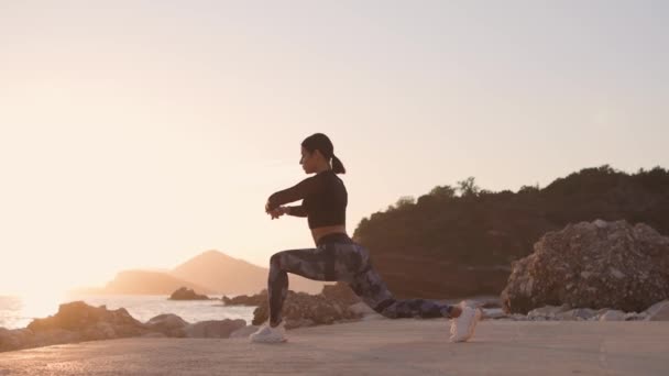 Jogger donna sportiva che si estende sulla spiaggia con vista mare — Video Stock