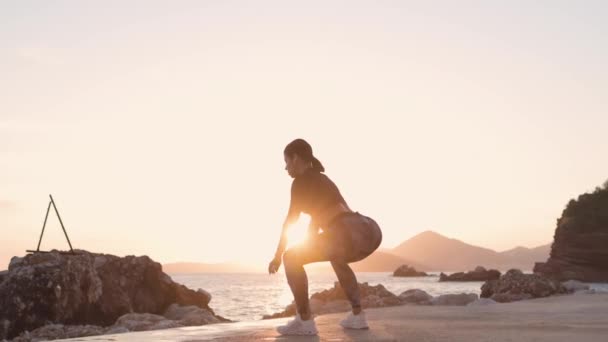 Sportos nő nyújtás edzés a strandon naplemente — Stock videók