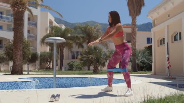 Sportig kvinna elastisk band knäböj övningar — Stockvideo
