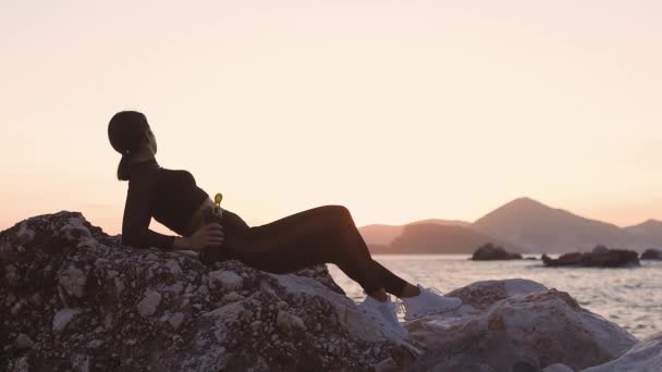 Sportieve vrouw ontspannen met eiwit shaker fles buiten strand zonsondergang — Stockvideo