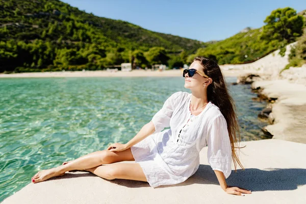 Jovem mulher relaxante na praia em vestido de verão — Fotografia de Stock