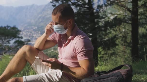 Man neemt medisch gezichtsmasker af en ademt buitenlucht in de bergen — Stockvideo