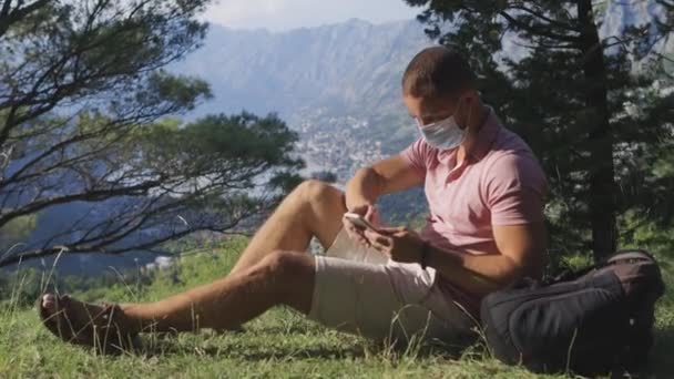 Férfi használ okostelefon védő maszk utazás hegyi erdő — Stock videók