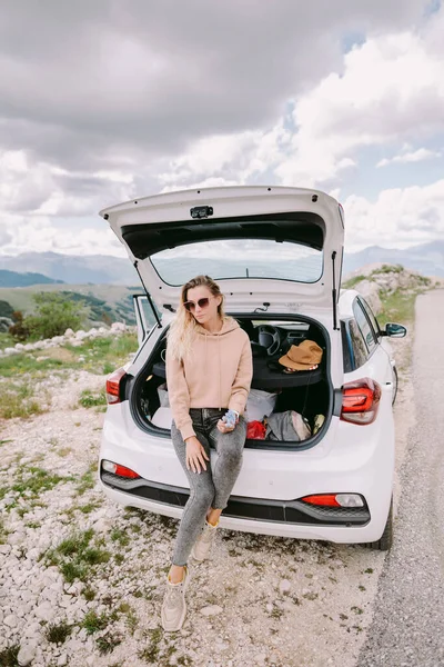 smiling woman relax in car driving in mountains