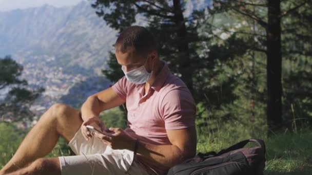 Uomo viaggiare e rimuovere maschera medica e respirare aria in montagna — Video Stock