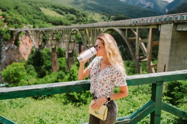Musafir wanita minum kopi dengan pemandangan pegunungan — Stok Foto