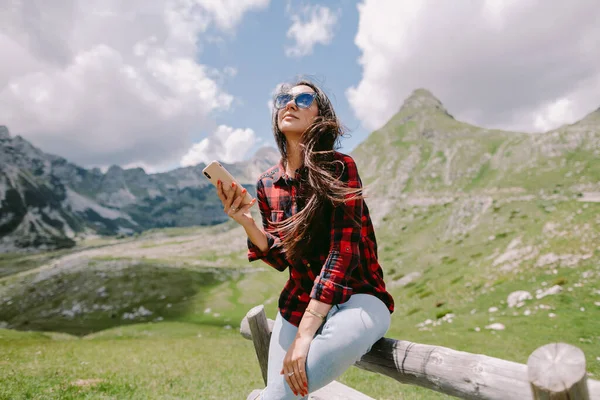 Привлекательная женщина путешественник с помощью смартфона в горах — стоковое фото