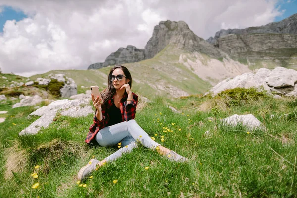 Pengelana wanita menggunakan smartphone di pegunungan — Stok Foto