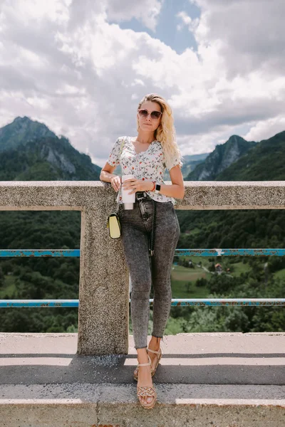 Vonzó nő utazó pihenni a hegyekben, és gazdaság kávésbögre — Stock Fotó