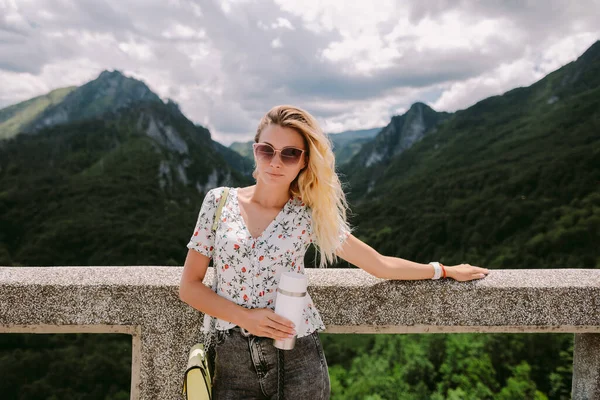 Wanita pelancong menarik memegang cangkir kopi dengan pemandangan pegunungan — Stok Foto