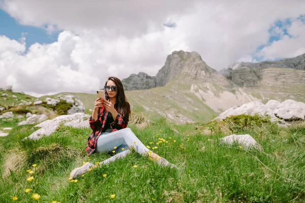 Женщина путешественник с помощью смартфона в горах — стоковое фото