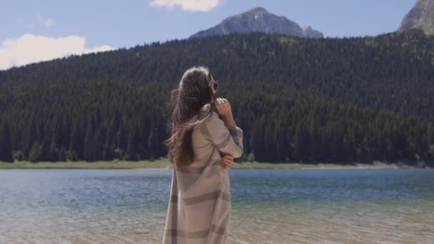 Mujer atractiva relajarse en las montañas con vista al lago en vacaciones — Vídeos de Stock