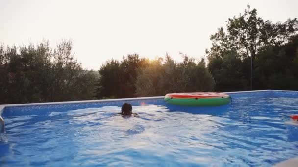 日落时妇女在游泳池里放松 — 图库视频影像