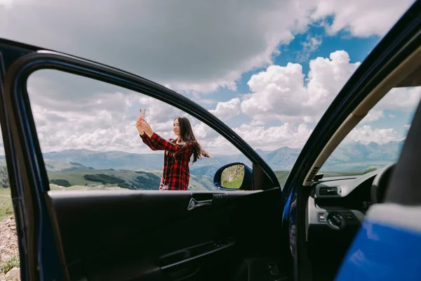 Wanita cantik bepergian dengan mobil dan menggunakan smartphone pada liburan perjalanan — Stok Foto