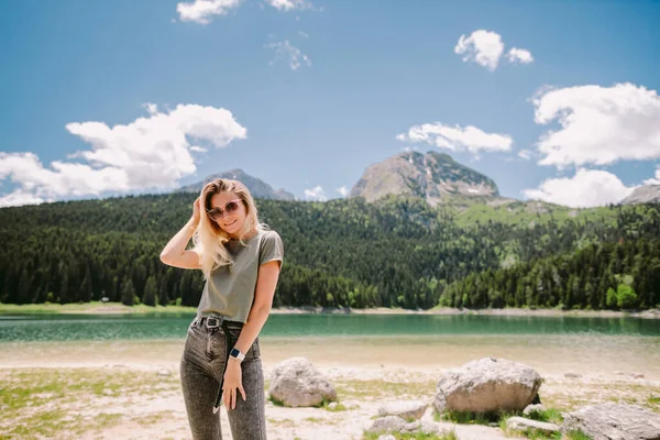 Wanita yang menarik santai di pegunungan dengan pemandangan danau dan hutan — Stok Foto