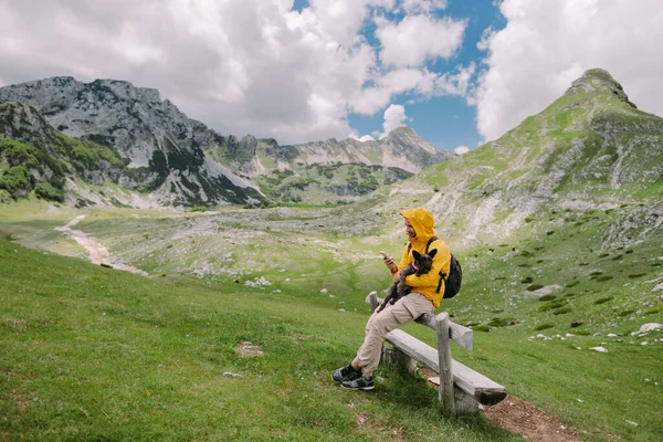 Muž cestování se psem pomocí smartphone na venkově s horami scénický pohled — Stock fotografie