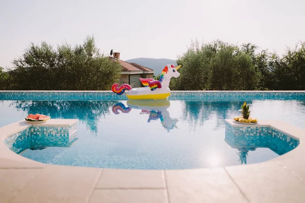 Kolam renang yang indah dengan mainan kolam renang tiup unicorn mengambang — Stok Foto