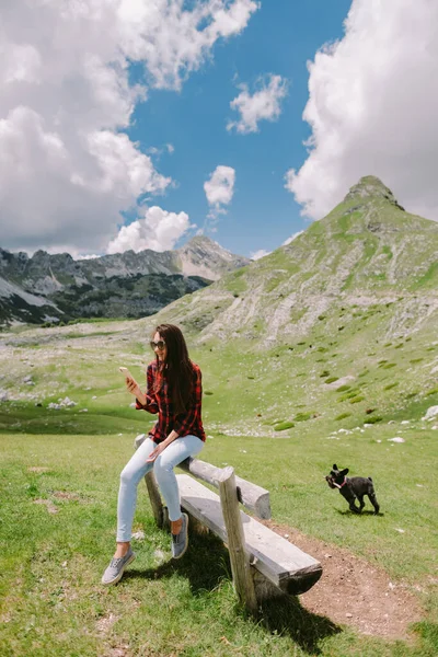 Mooie vrouw reizen met hond en met behulp van smartphone op het platteland — Stockfoto