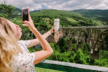 Kadınlar seyahat eder ve kırsal kesimde akıllı telefondan fotoğraf çeker.