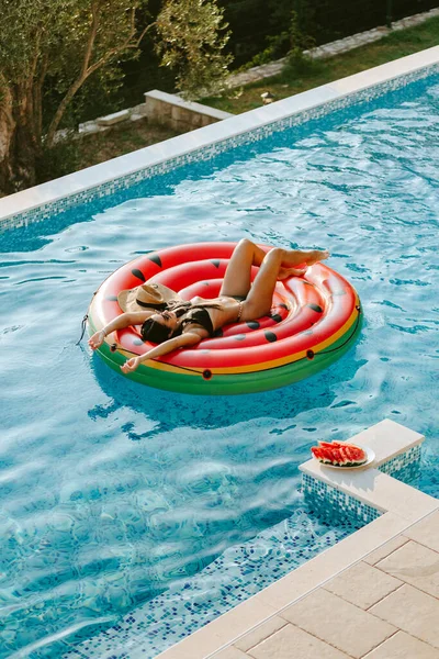 Wanita seksi bersantai di kolam renang pada karet menyenangkan pantai mengambang di luar ruangan — Stok Foto