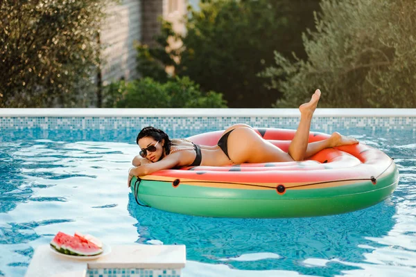 Sexy woman relax in swimming pool on inflatable fun beach floaty outdoors — Stock Photo, Image