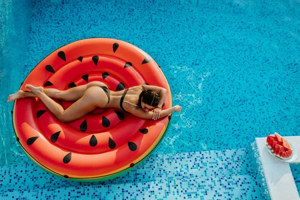 Wanita bersantai di kolam renang pada karet kolam renang mainan pada hari musim panas — Stok Foto