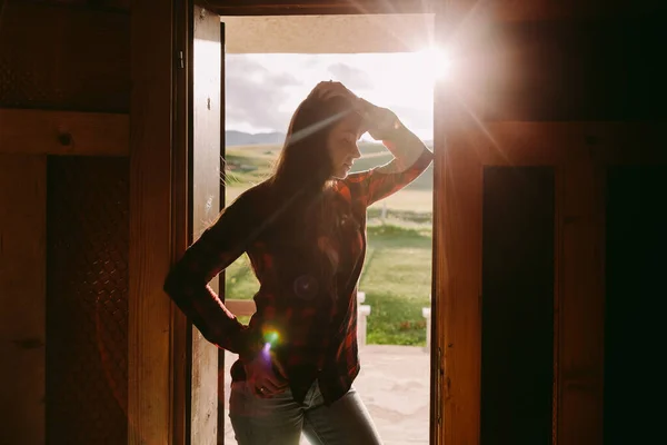 Retrato de mulher na porta da casa com luz solar — Fotografia de Stock